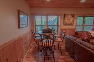 a living room with a table and chairs and a couch at Poppy’s Place Cabin in Dandridge