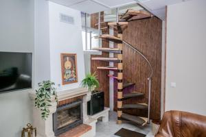 a spiral staircase in a living room with a fireplace at Guest house LORA in Gabrovo