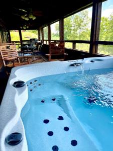 a jacuzzi tub with blue water in a house at Poppy’s Place Cabin in Dandridge