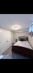 a bedroom with a large bed and white cabinets at BASEMENT APARTMENT Two Bedrooms in Whitby