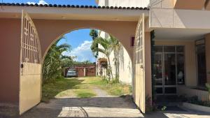 ein Torbogen, der in ein Gebäude mit einer Auffahrt führt in der Unterkunft Hotel Monte Azul in Tarapoto