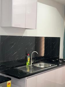 a kitchen with a sink and a black counter top at Afse apartments Peduase in Aburi +44 photos