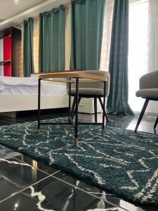 a room with a table and two chairs and a bed at Afse apartments Peduase in Aburi