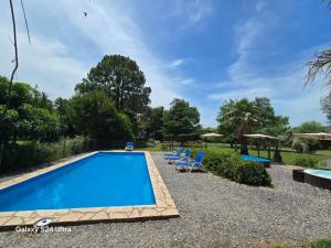 a swimming pool in a yard with lounge chairs at La Chacra Hotel Campo y Spa in San Pedro