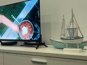 a tv on a table with a toy boat on it at Afse apartments Peduase in Aburi