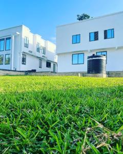 a field of grass in front of a building at Afse apartments Peduase in Aburi