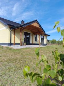 a house with a large yard in front of it at Domek na Polanie Rekowo in Pollnow
