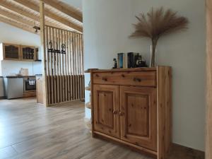 a kitchen with a wooden cabinet with a plant on it at Domek na Polanie Rekowo in Pollnow +4 photos