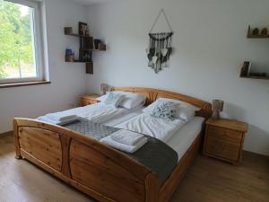 a large wooden bed in a room with a window at Domek na Polanie Rekowo in Pollnow