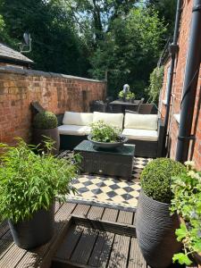 a patio with two couches and potted plants at Albany house Harborne in Birmingham