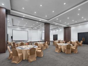 a conference room with tables and chairs and a screen at Pullman Bali Legian Beach in Legian +115 photos