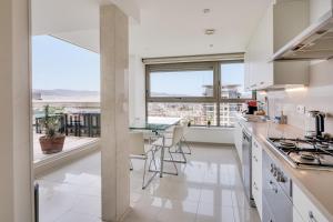 a kitchen with white appliances and a large window at Penthouse Duplex with Epic Views in Barcelona
