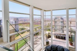 a view from the top of a building with tall windows at Penthouse Duplex with Epic Views in Barcelona