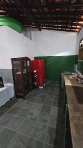 a kitchen with a red refrigerator in a room at Acomodações as casinhas da ada in Coruripe