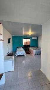 a large room with two beds and a tiled floor at Acomodações as casinhas da ada in Coruripe