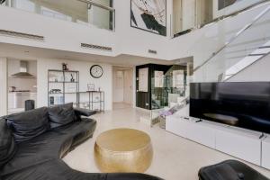 a living room with a couch and a large tv at Penthouse Duplex with Epic Views in Barcelona