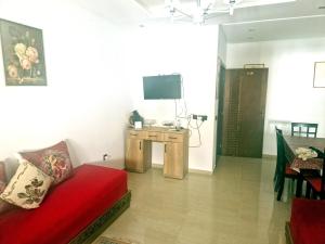 a living room with a red couch and a table with a television at la Casa de doha in Tangier