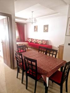 a dining room with a table and chairs and a couch at la Casa de doha in Tangier