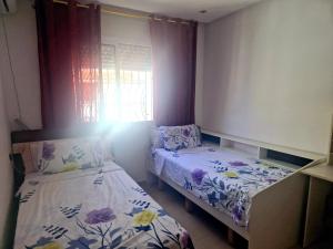 a small bedroom with two beds and a window at la Casa de doha in Tangier