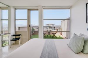 a bedroom with a large white bed and large windows at Penthouse Duplex with Epic Views in Barcelona