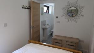 a bedroom with a bed and a sink and a mirror at The Annexe in West Buckland