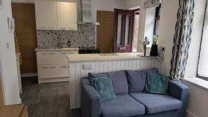 a living room with a blue couch in a kitchen at The Annexe in West Buckland