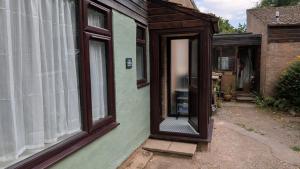an open door of a house with a window at The Annexe in West Buckland