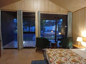a bedroom with a bed and a large window at Shivir Aranya - Wilderness Resort Sariska in Alwar