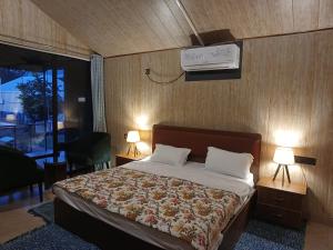 a bedroom with a bed with two lamps and a tv at Shivir Aranya - Wilderness Resort Sariska in Alwar
