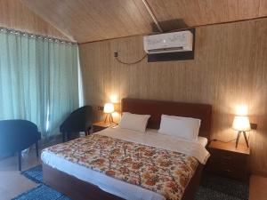 a bedroom with a bed and a tv on the wall at Shivir Aranya - Wilderness Resort Sariska in Alwar