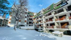 a large building with snow in front of it at La Pigna - Maison dOc in Bardonecchia