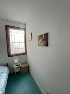 a bedroom with a bed and a window and a table at Le Lotus - 5 in Cherbourg en Cotentin +3 photos