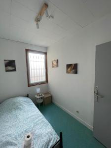 a bedroom with a bed and a window at Le Lotus - 5 in Cherbourg en Cotentin