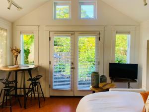 a bedroom with a bed and a tv and windows at Star Studio, A Garden Retreat near University of Oregon in Eugene