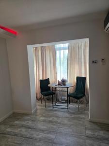 a dining room with a table and chairs and a window at Smart Apartament in Brăila