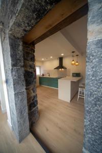 a kitchen and living room with a stone wall at Un buen día in Ramales de la Victoria +16 photos