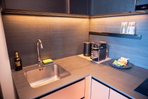 a kitchen counter with a sink and a bottle of wine at EDGE Central Pattaya 2BR Ocean View Luxury Condo Rooftop Pool Central Location in Pattaya +61 photos