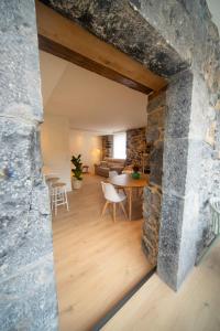 a living room with a stone wall and a table at Un buen día in Ramales de la Victoria