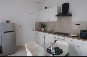 a kitchen with a glass table and white cabinets at JBM Appartement spéciaux Gare de Vilvorde - Bruxelles Airport &Brussel Expo in Vilvoorde