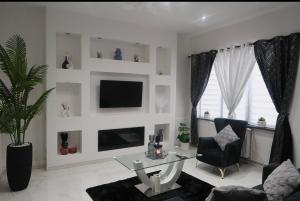 a living room with a glass table and a tv at JBM Appartement spéciaux Gare de Vilvorde - Bruxelles Airport &Brussel Expo in Vilvoorde