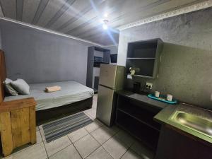 a small room with a refrigerator and a kitchen at Zairasbread in White River