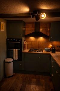 a kitchen with green cabinets and a stove top oven at Luxury Countryside Escape in Ipsden