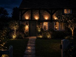 a house with lights on the front of it at night at Luxury Countryside Escape in Ipsden