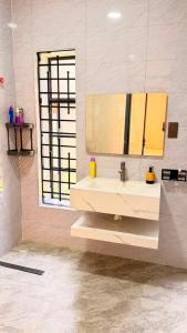 a bathroom with a sink and a mirror at EZER HOMEs in Kampala +24 photos