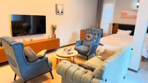 a hotel room with a bed and chairs and a living room at EZER HOMEs in Kampala