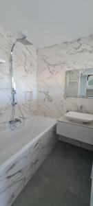 a white bathroom with a tub and a sink at Les chambres de Dolce in Bandol