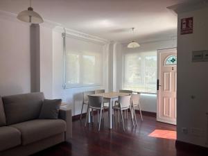 a living room with a table and chairs and a couch at Apartamentos La Reserva Isla "Playa de la Cava" in Isla