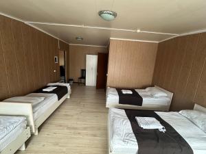 a room with three beds in a room at Green House in Karakol