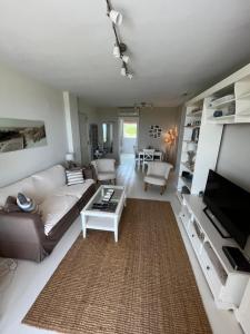 a living room with a couch and a tv at Condo with golf course views, pool and terraces in San Jorge