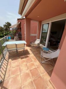 a patio with a table and chairs on a balcony at Condo with golf course views, pool and terraces in San Jorge